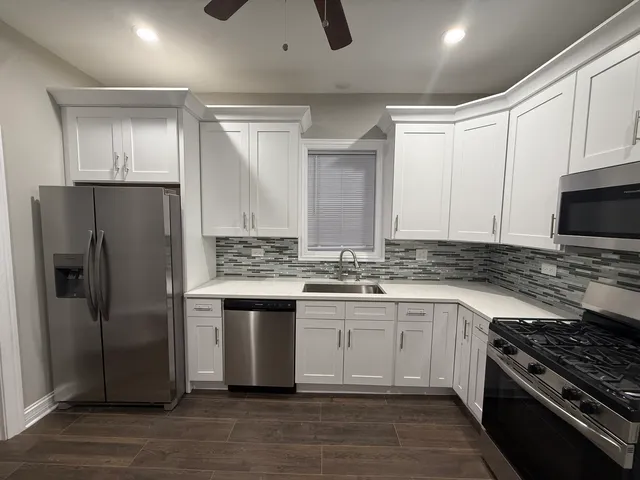 a kitchen with stainless steel appliances granite countertop a stove a refrigerator and a sink