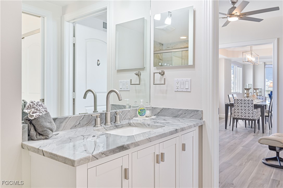 2104 West First Street, Unit 1701 Fort Myers, FL 33901 - Photo 18 of 48 a bathroom with a granite countertop sink a large mirror and vanity