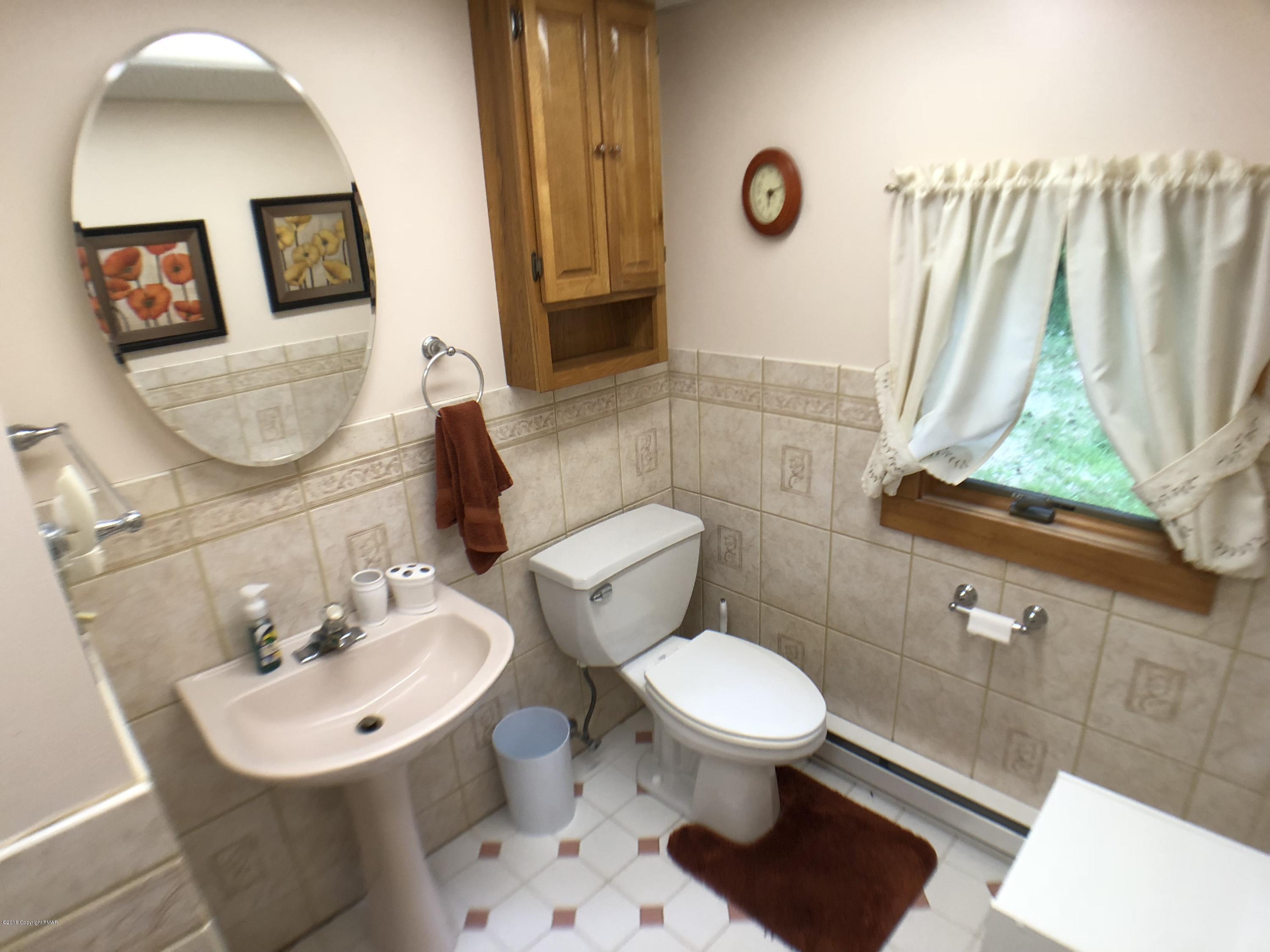 2212 Abby Road Pocono Pines, PA 18350 - Photo 4 of 22 a bathroom with a toilet sink and mirror