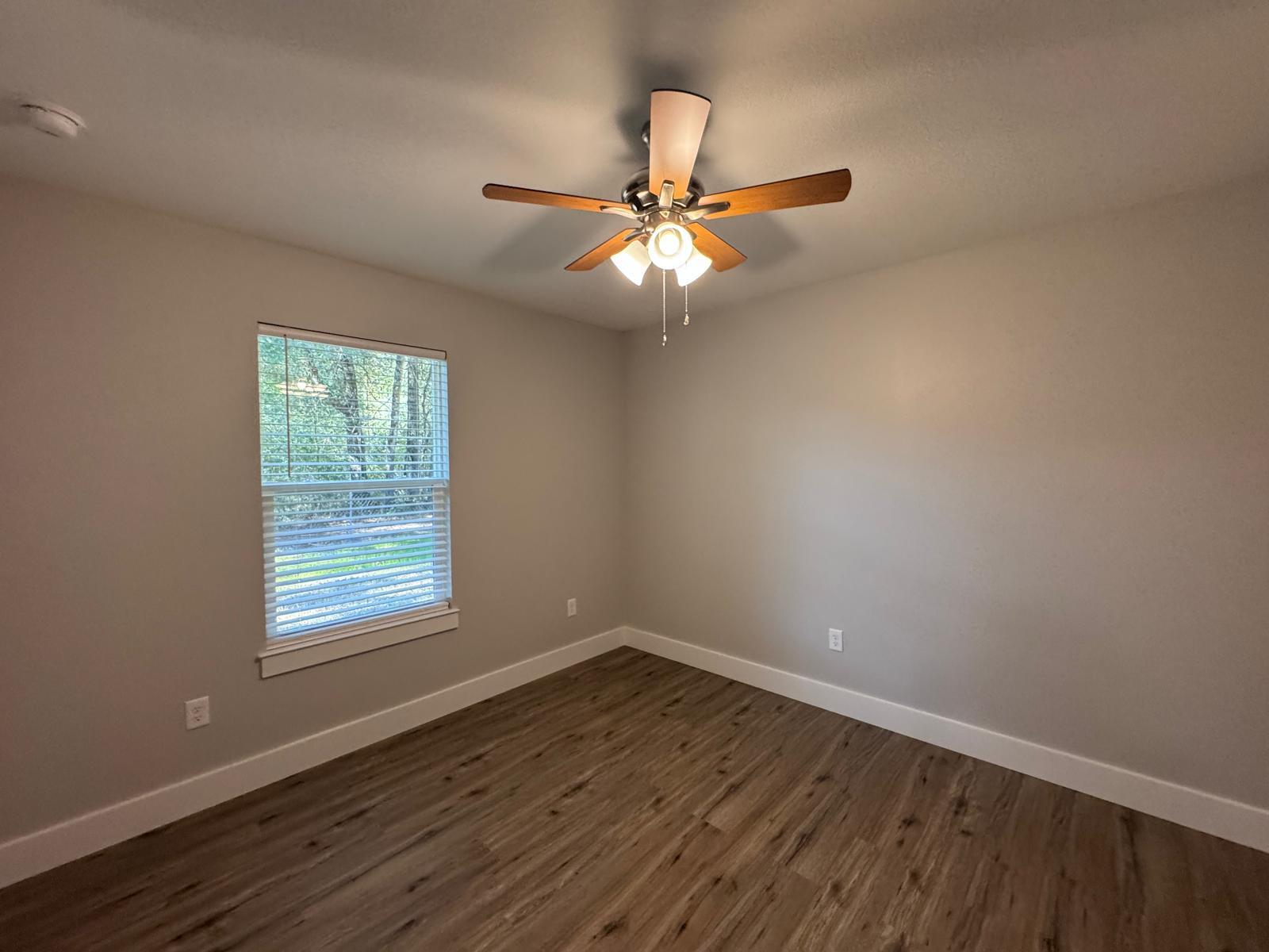 1787 Dads Road Baker, FL 32531 - Photo 12 of 20 an empty room with wooden floor fan and windows