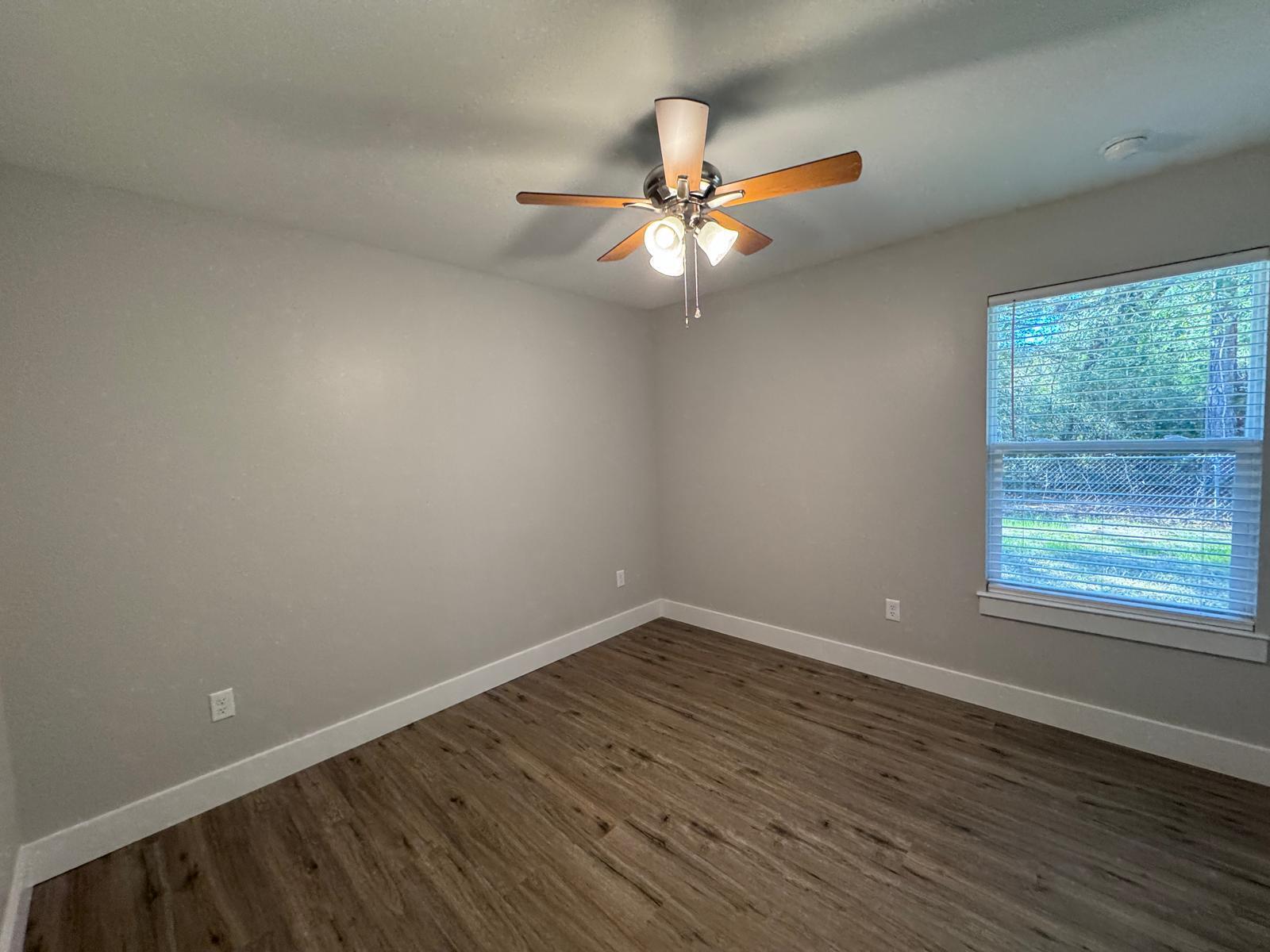 1787 Dads Road Baker, FL 32531 - Photo 15 of 20 an empty room with wooden floor fan and windows