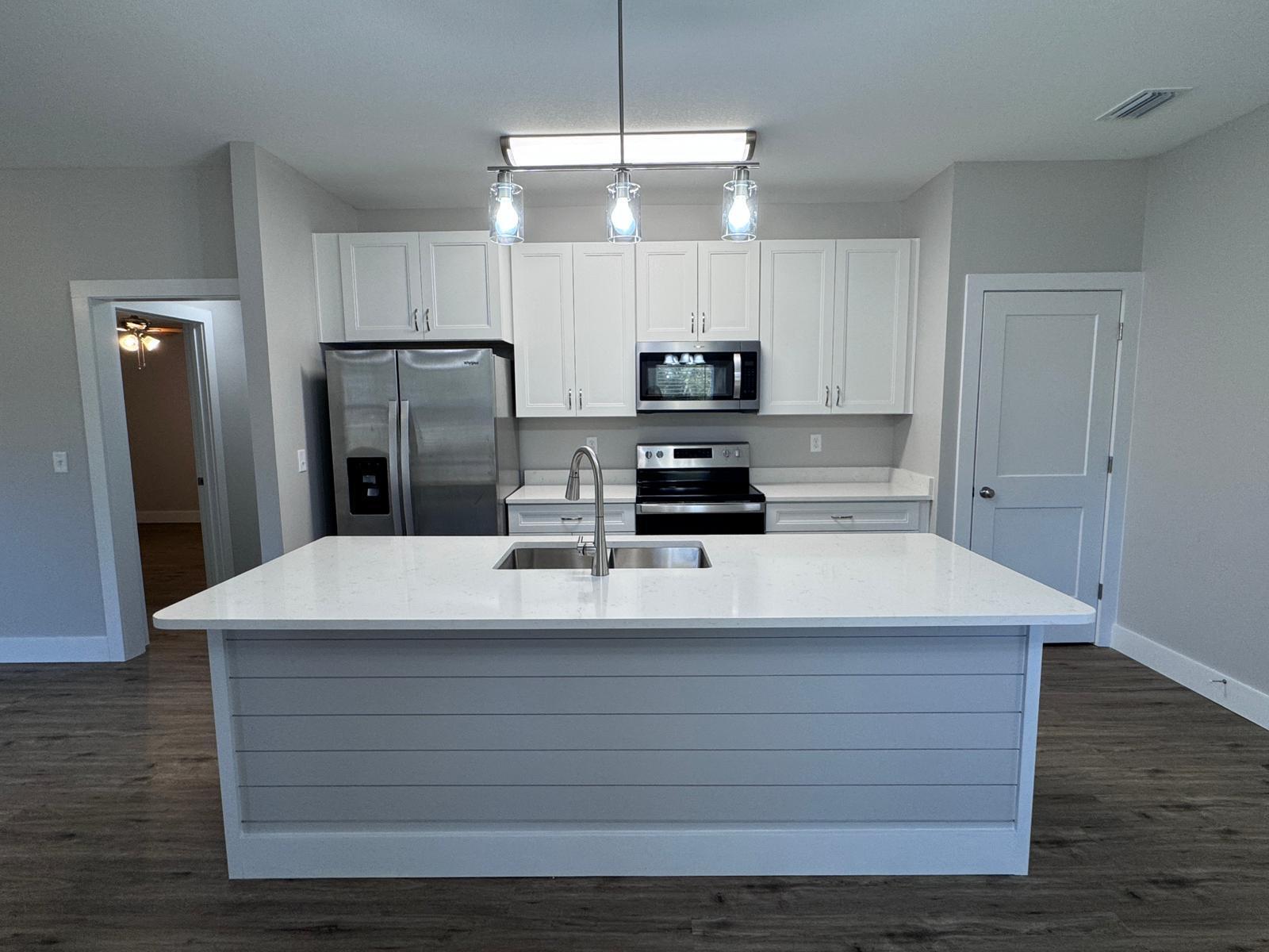 1787 Dads Road Baker, FL 32531 - Photo 4 of 20 a room with kitchen island white cabinets and stainless steel appliances