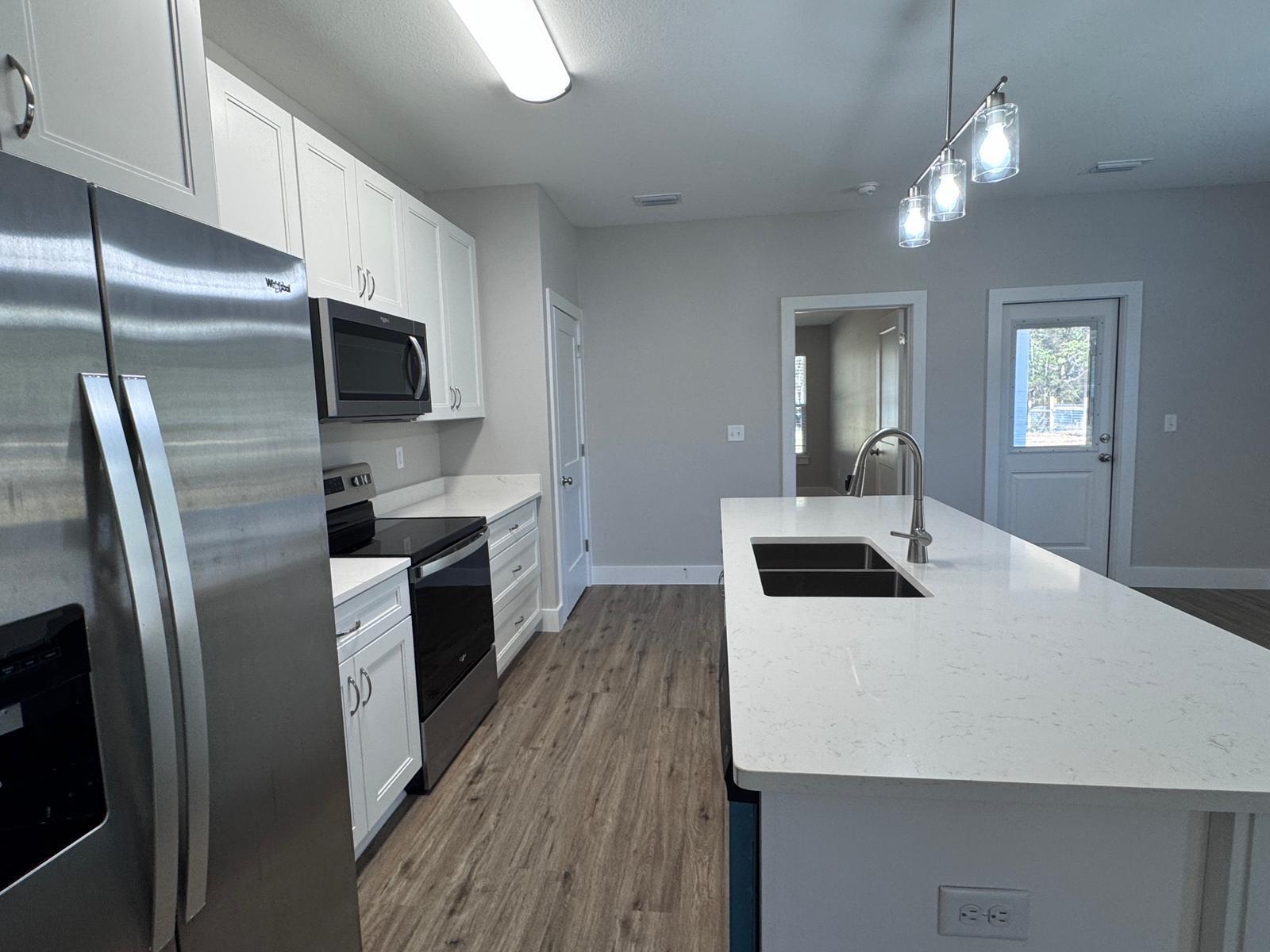 1787 Dads Road Baker, FL 32531 - Photo 5 of 20 a kitchen with sink a refrigerator and a stove top oven