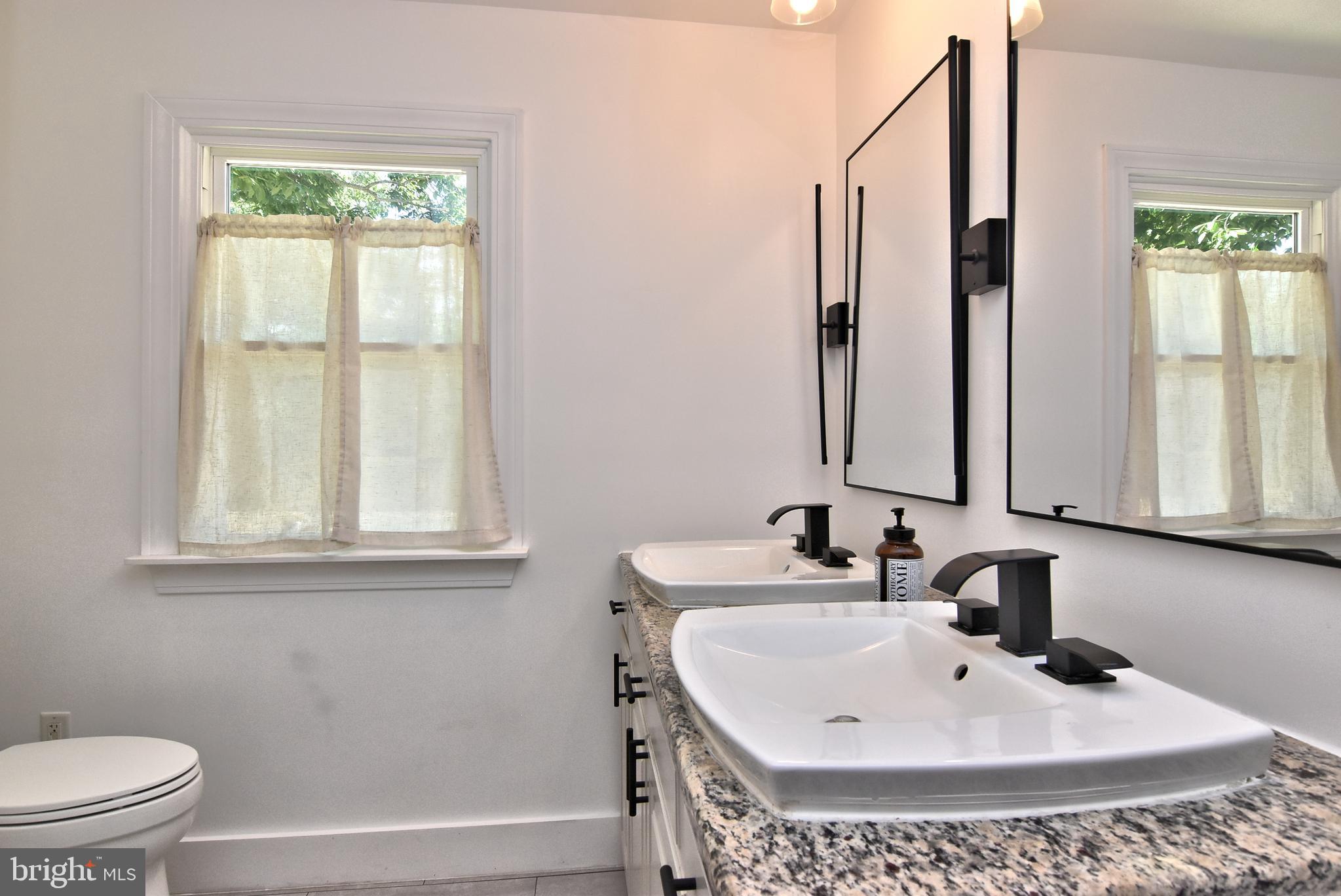 9012 Concord Road Seaford, DE 19973 - Photo 17 of 24 a bathroom with a sink a toilet and a window