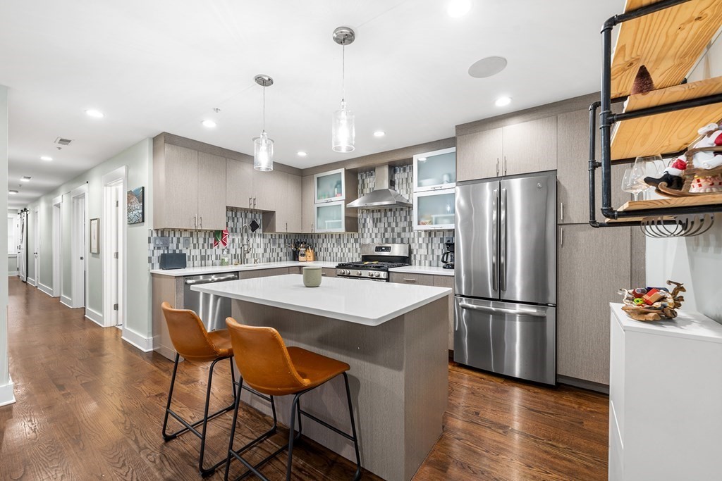 13 Ruthven Street, Unit 1 Boston, MA 02121 - Photo 12 of 35 a kitchen with stainless steel appliances a refrigerator a stove a sink dishwasher and a refrigerator with wooden floor