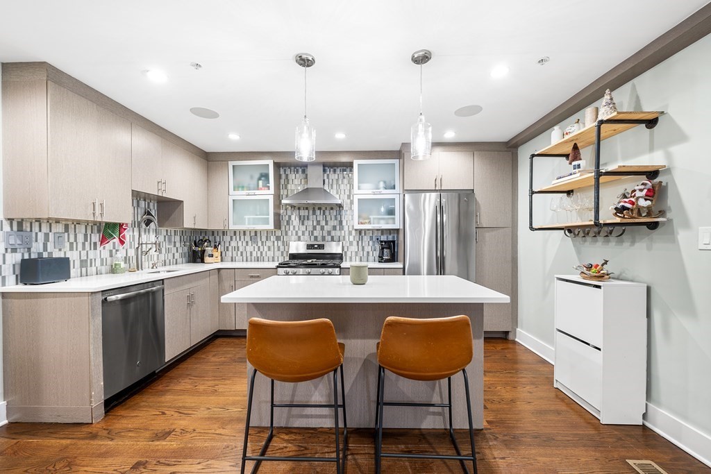 13 Ruthven Street, Unit 1 Boston, MA 02121 - Photo 6 of 35 a kitchen with stainless steel appliances granite countertop a table chairs stove a sink and dishwasher