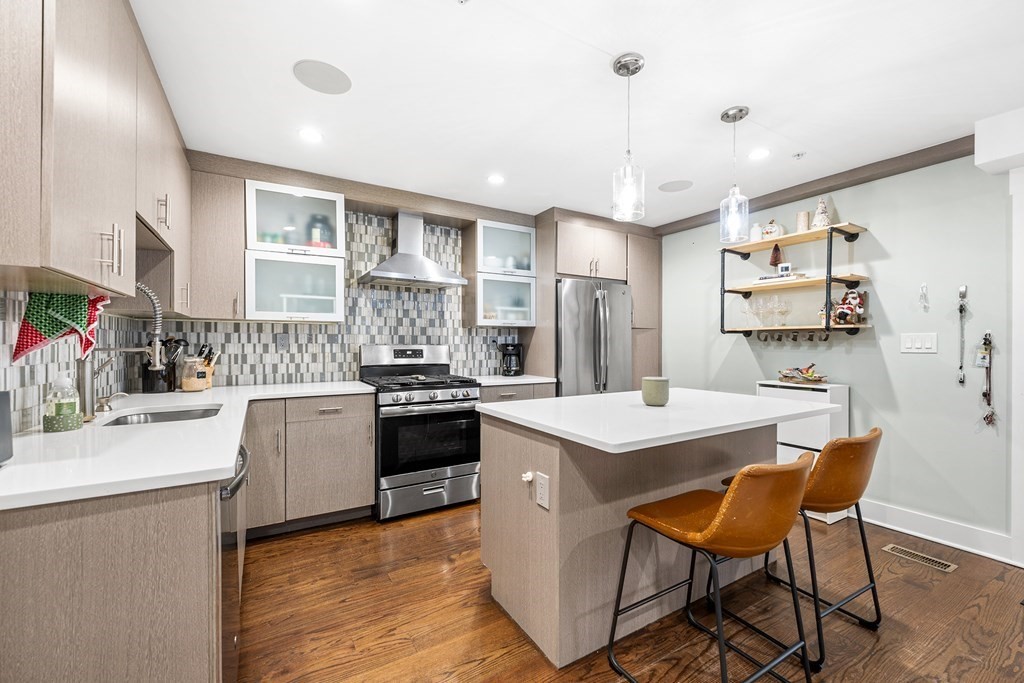 13 Ruthven Street, Unit 1 Boston, MA 02121 - Photo 7 of 35 a kitchen with stainless steel appliances kitchen island granite countertop a sink stove and refrigerator