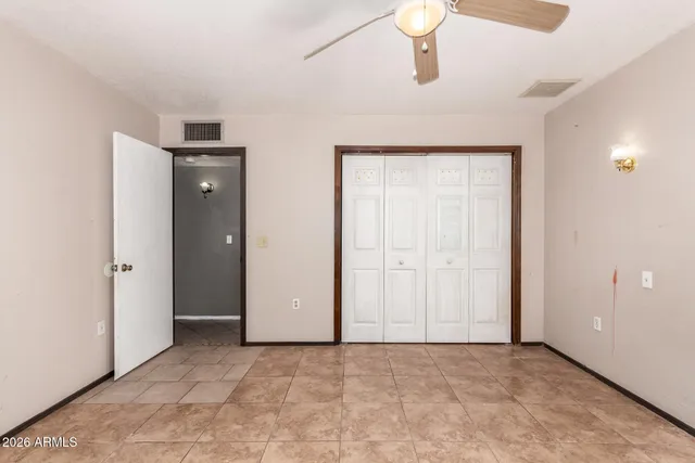 a view of a livingroom with a fireplace a ceiling fan and window