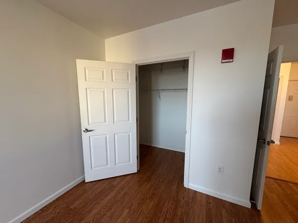 an empty room with wooden floor and closet