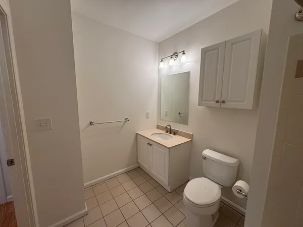 a bathroom with a granite countertop toilet a sink and a mirror