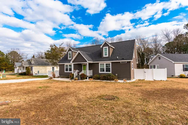 a front view of a house with a yard covered with snow