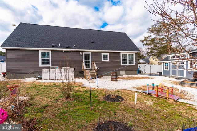 a backyard of a house with table and chairs with wooden fence