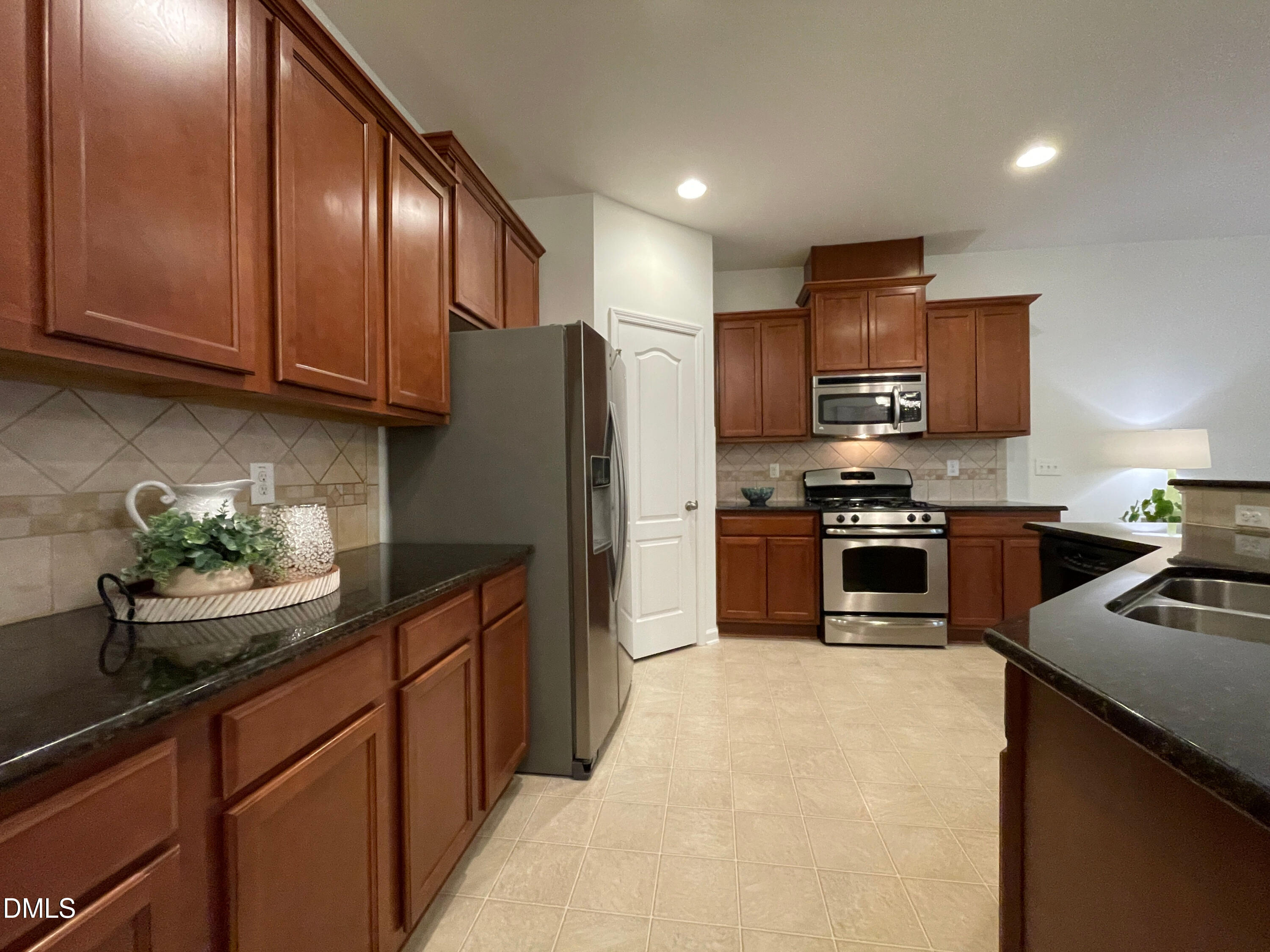 8257 Primanti Boulevard Raleigh, NC 27612 - Photo 11 of 27 a kitchen with stainless steel appliances granite countertop a refrigerator sink and stove