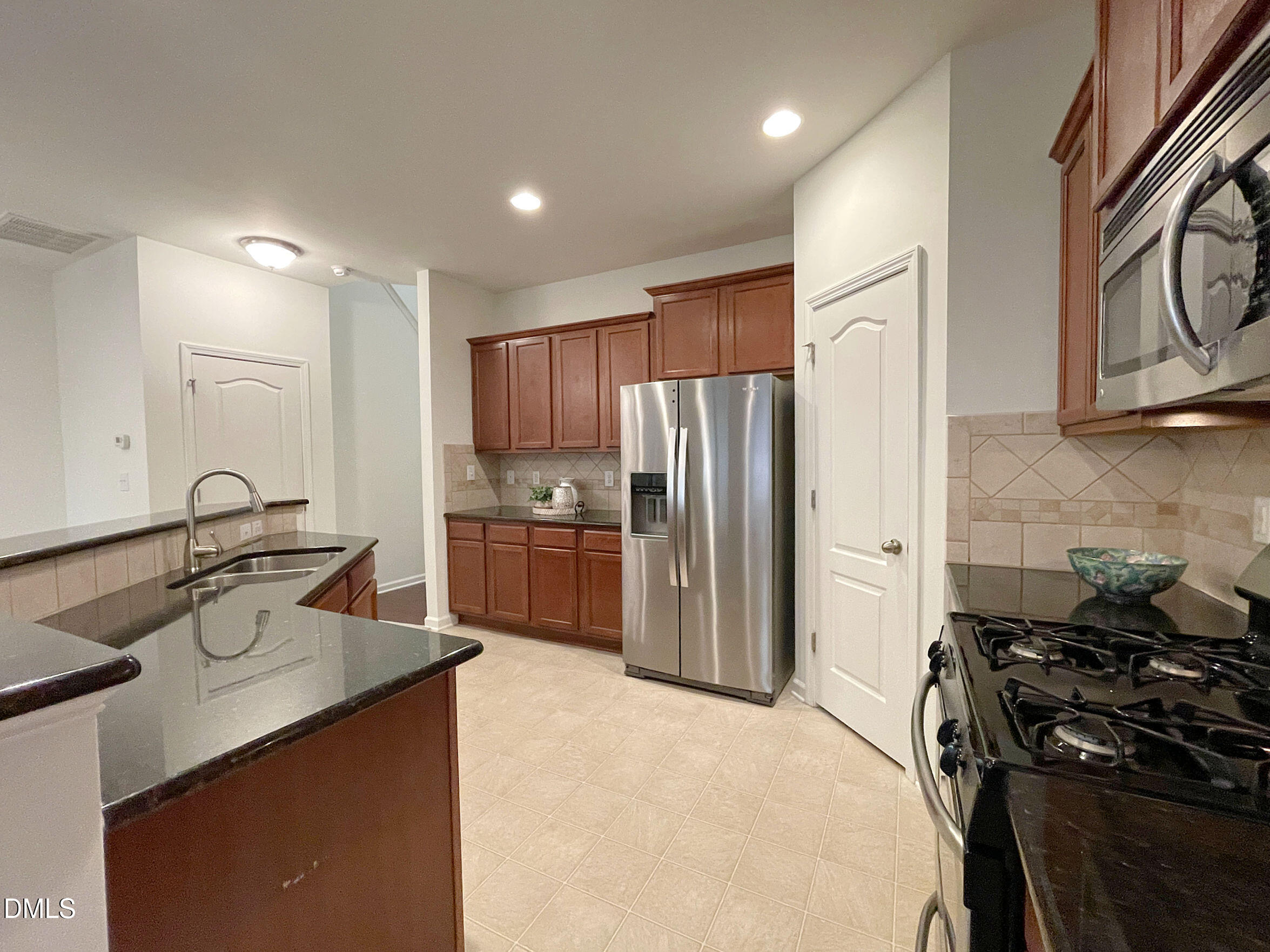 8257 Primanti Boulevard Raleigh, NC 27612 - Photo 13 of 27 a kitchen with granite countertop a sink stove and refrigerator