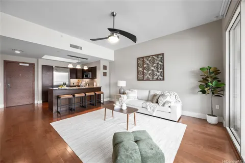 a living room with furniture kitchen view and a potted plant