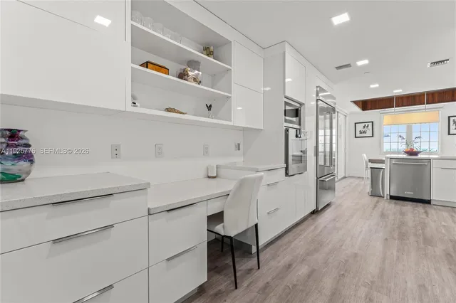 a kitchen with white cabinets and white appliances