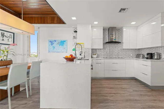 a kitchen with stainless steel appliances granite countertop a refrigerator and a stove top oven