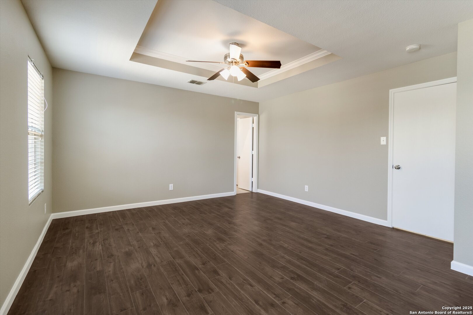 25002 Orchard Acres San Antonio, TX 78261 - Photo 15 of 29 an empty room with wooden floor ceiling fan and windows