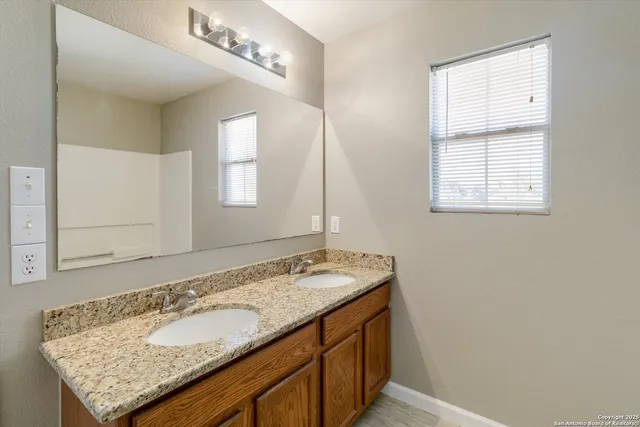 a bathroom with a granite countertop sink and a mirror