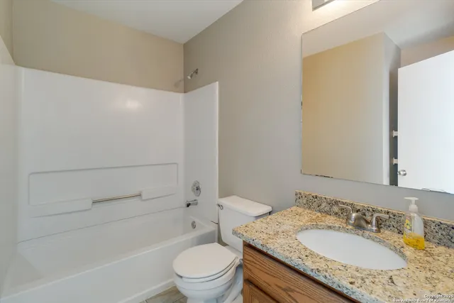 a bathroom with a granite countertop sink toilet and shower