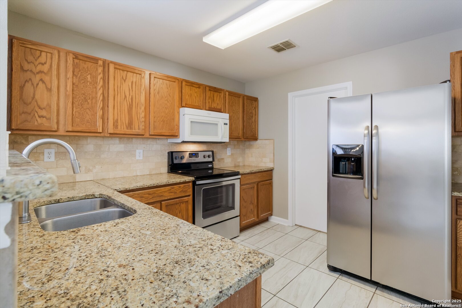 25002 Orchard Acres San Antonio, TX 78261 - Photo 9 of 29 a kitchen with a refrigerator sink and cabinets