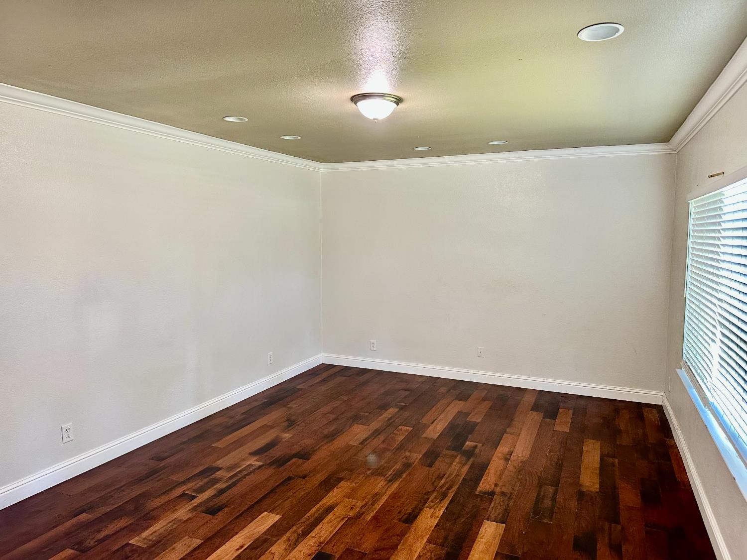 5683 North Rafael Avenue Fresno, CA 93711 - Photo 4 of 19 an empty room with wooden floor and windows