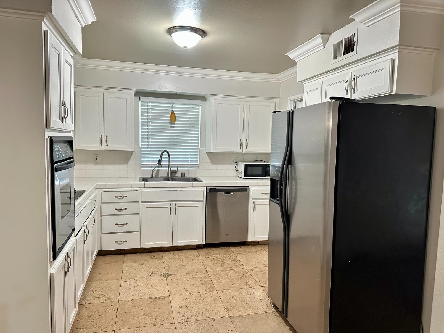 5683 North Rafael Avenue Fresno, CA 93711 - Photo 6 of 19 a kitchen with white cabinets and refrigerator