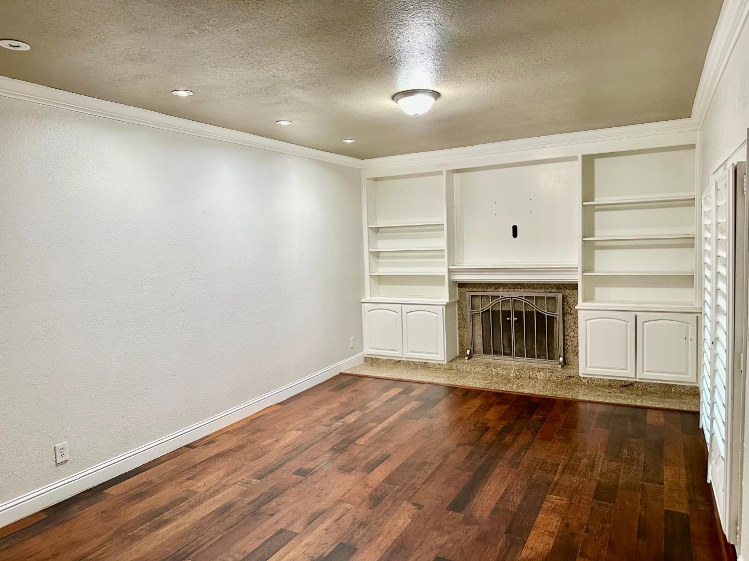 5683 North Rafael Avenue Fresno, CA 93711 - Photo 7 of 19 a view of an empty room with wooden floor fireplace and a window