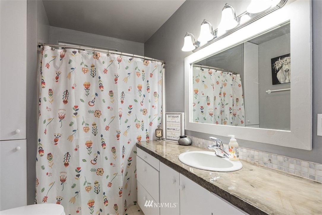 2959 Main Street Custer, WA 98240 - Photo 17 of 33 a bathroom with a granite countertop sink a mirror a shower curtain and a bathroom