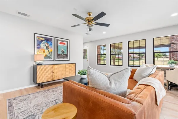 a living room with furniture ceiling fan and a window