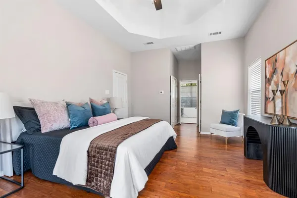 a spacious bedroom with a bed and wooden floor