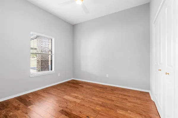 an empty room with wooden floor and closet