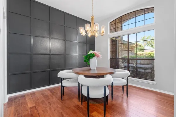 a view of a dining room with furniture a chandelier and wooden floor