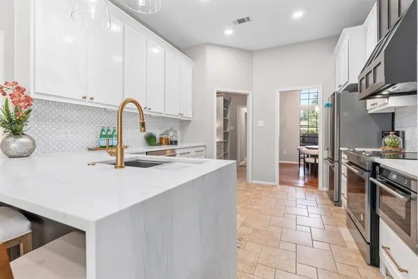 a kitchen with stainless steel appliances a sink stove and cabinets