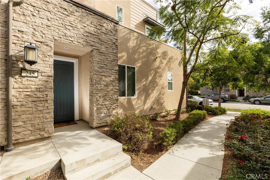a view of a brick house with a large windows and flower plants