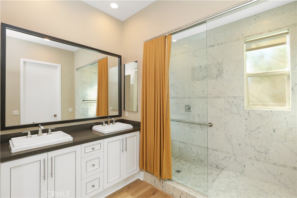 245 Follyhatch Irvine, CA 92618 - Photo 26 of 44 a bathroom with a granite countertop sink a mirror and a shower