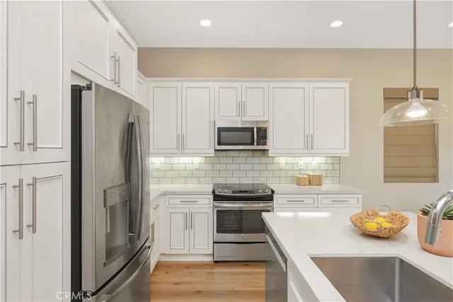 a kitchen with stainless steel appliances and white cabinets