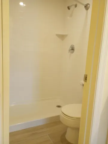 a bathroom with a white toilet and a shower