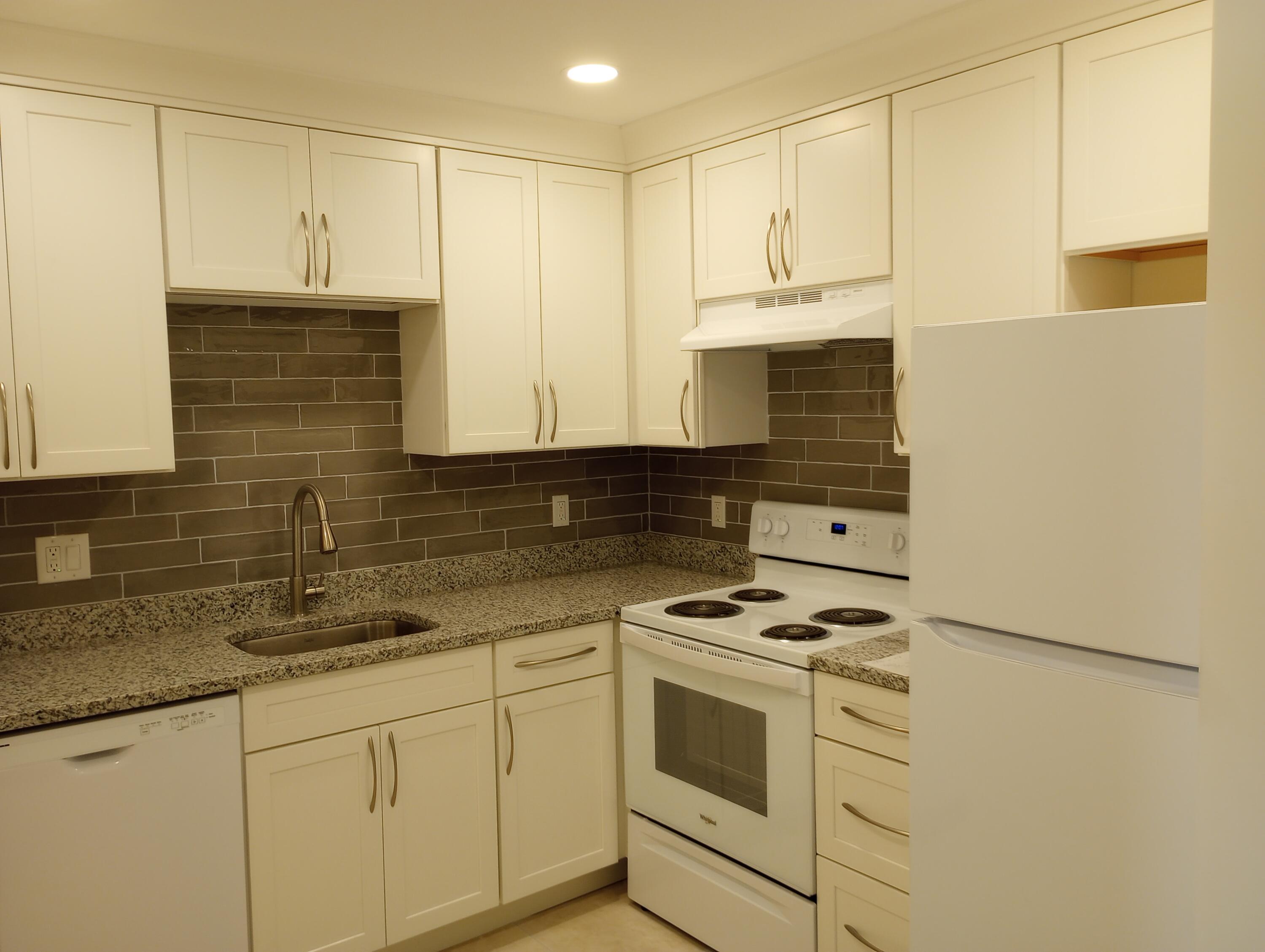 950 South Kanner Highway, Unit A21 Stuart, FL 34994 - Photo 3 of 24 a kitchen with granite countertop white cabinets and white appliances