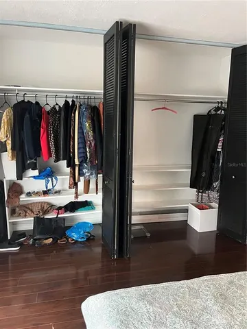 a view of walk in closet with clothes and shoes