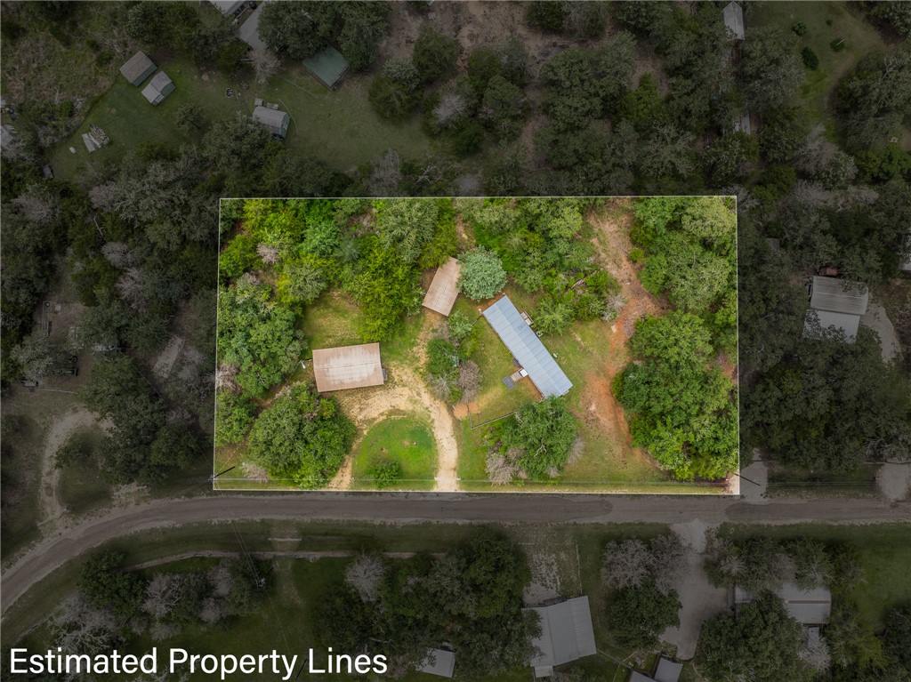 an aerial view of a residential houses with outdoor space and trees