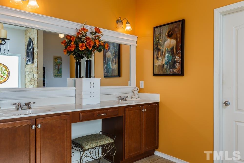 131 Daneborg Road Durham, NC 27703 - Photo 14 of 25 Dual sinks, expansive counter top, an oversized, framed mirror and wide tile floors accommodate shared morning routines a breeze! (Wait until you see the size of the walk in closet!)