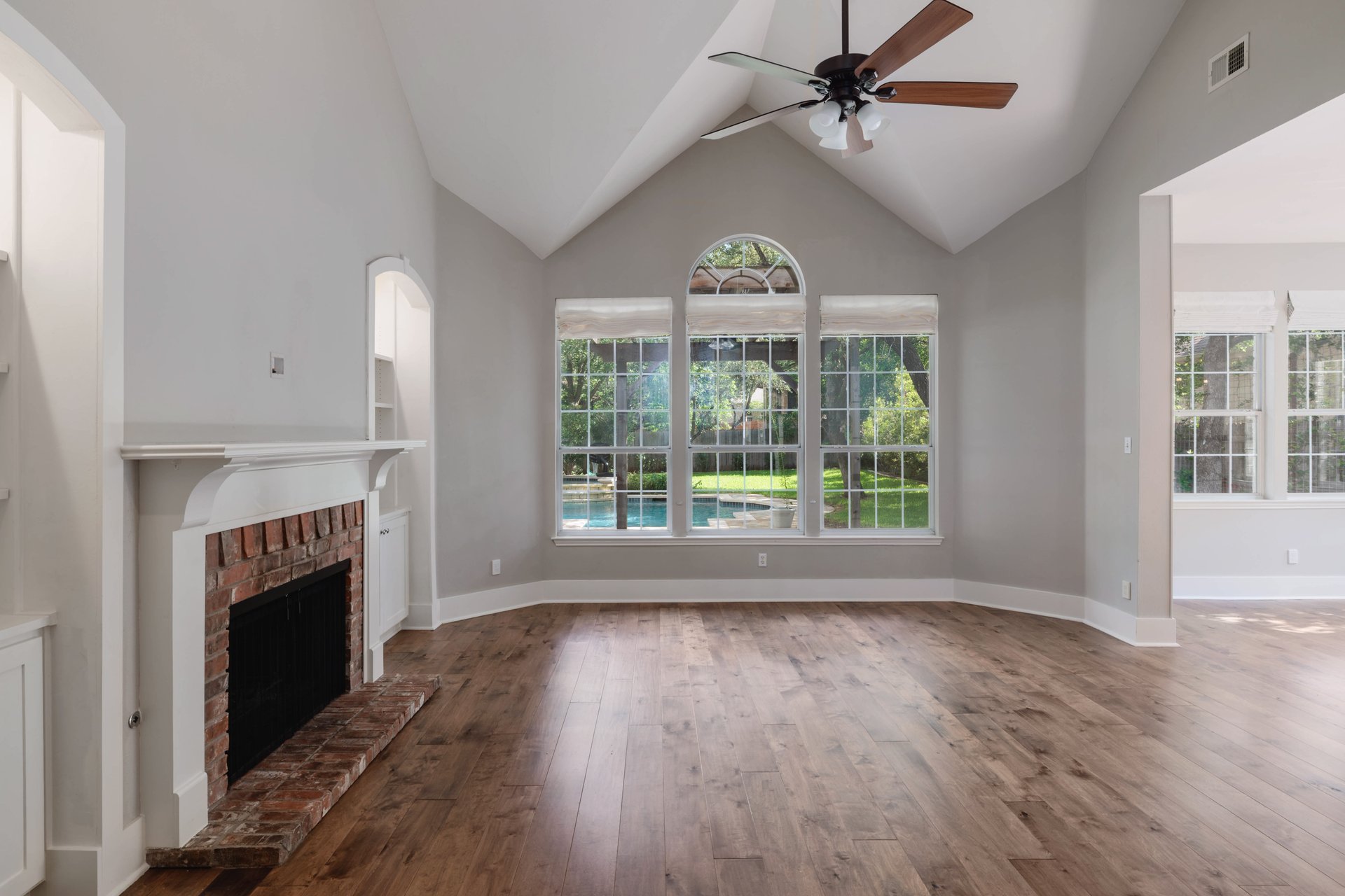 5512 Ballenton Lane Austin, TX 78739 - Photo 9 of 40 A spacious living area with vaulted ceilings offers picturesque views of a private pool and verdant yard.