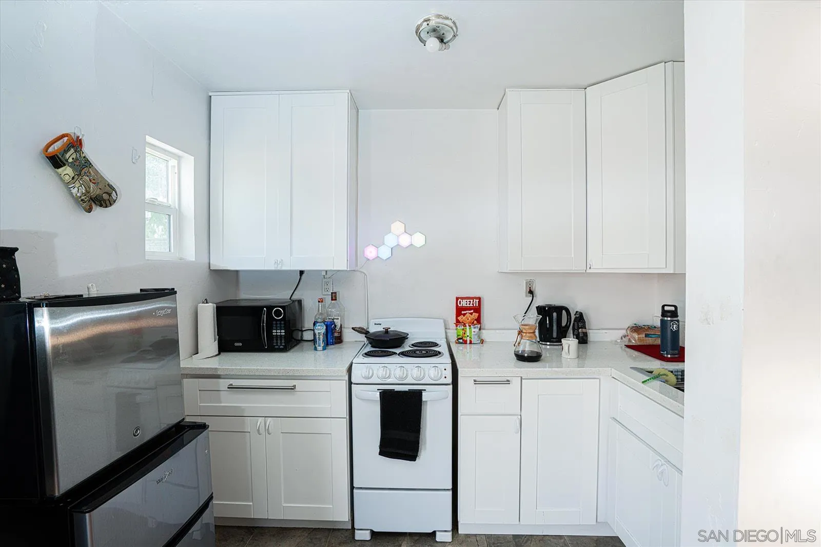5451 Redding Road San Diego, CA 92115 - Photo 34 of 37 a kitchen with white cabinets and white appliances