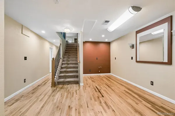 a view of an empty room with wooden floor and entryway