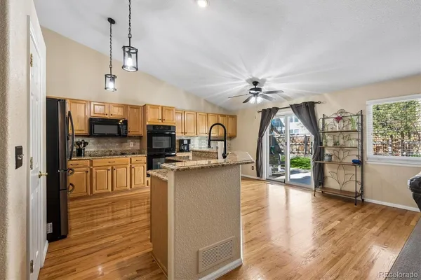 a view of a kitchen with sink and dishwasher a refrigerator with wooden floor