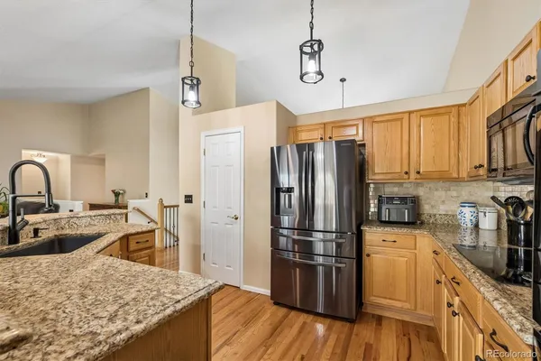 a kitchen with refrigerator cabinets and wooden floor