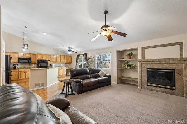 a living room with furniture kitchen view and a fireplace