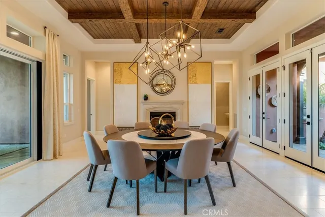 a dining room with furniture clock a fireplace and a chandelier