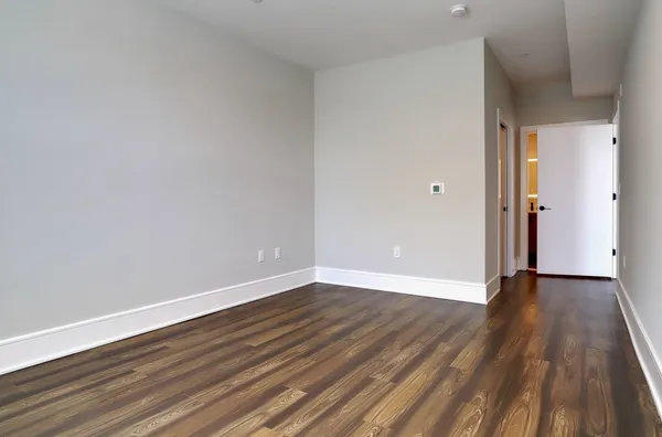 a view of an empty room and wooden floor